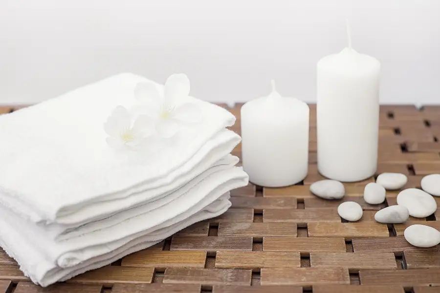 Upscale spa treatment room with folded towels and calm modern decor, representing discreet men’s grooming and skincare services
