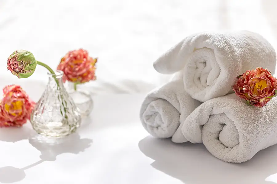 Upscale spa treatment room with folded towels and calming modern decor, representing private intimate beauty and skincare services
